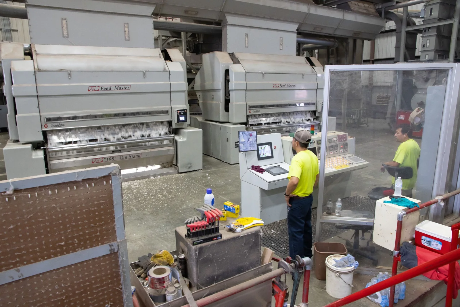 Workers operate cotton-gin machinery in North Carolina, United States.