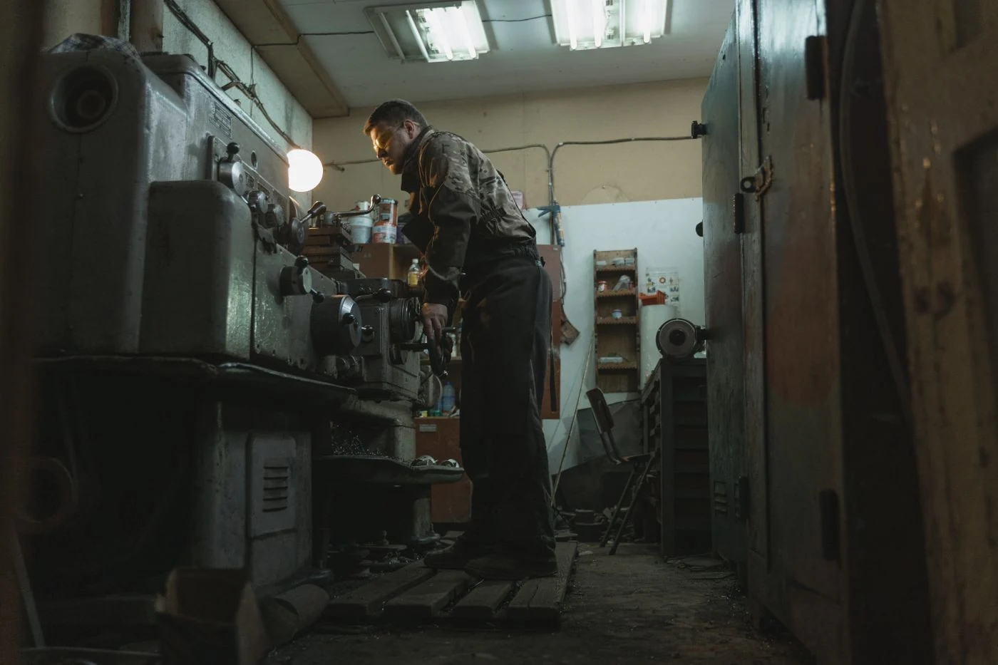 A craftsman operates a lathe in a metalworking shop. The source does not identify the location.